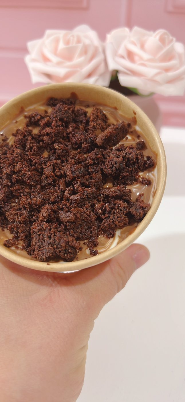 Cuchareable cremoso de chocolate saludable en vaso, cubierto de migas de bizcocho de cacao
