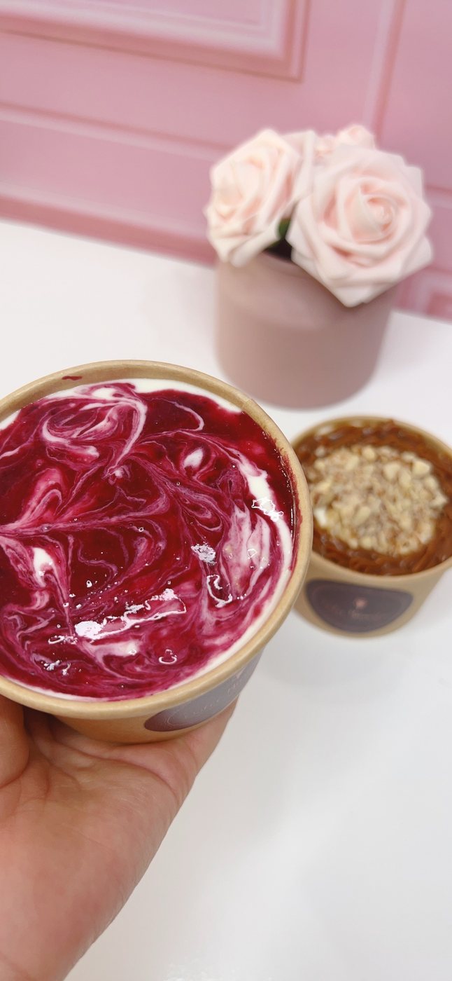 Cuchareable cremoso de frutos rojos saludable con mermelada marmoleada en la superficie