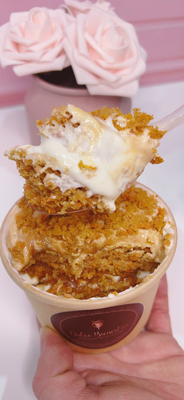 Cucharada de cuchareable cremoso de zanahoria saludable con crema y salsa de arequipe